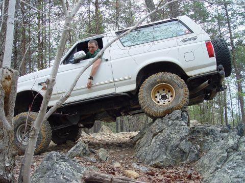 1996 Ford Bronco - This 1996 Ford Bronco is shown tackling a challenging off-road course with its tires climbing over large rocks.