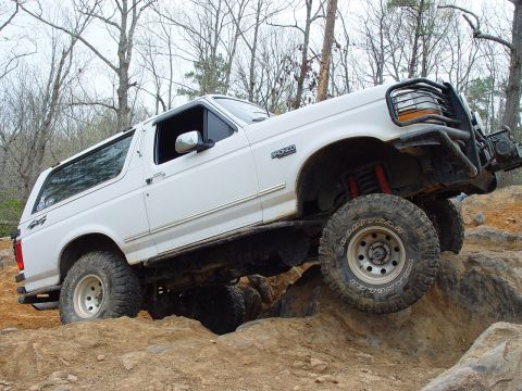 1996 Ford Bronco - White 1996 Ford Bronco navigating a rocky off-road course.