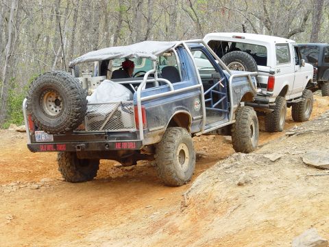 1996 Ford Bronco - Modified Ford Broncos and a Jeep navigate a challenging off-road trail.