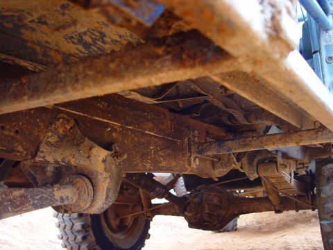 1996 Ford Bronco - The underside of a heavily rusted 4x4 vehicle, revealing its suspension and drivetrain components.
