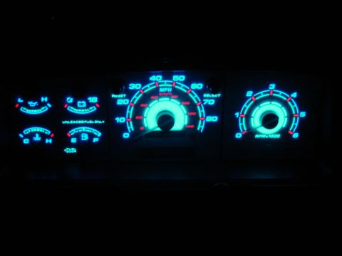 1996 Ford Bronco - A close-up view of a vehicle's illuminated dashboard gauges at night.