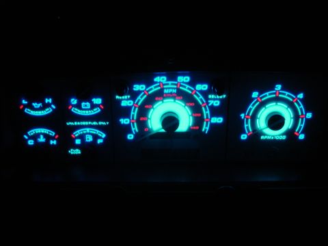 1996 Ford Bronco - Custom blue glowing dashboard gauges with illuminated MPH and RPM indicators are visible in the dark.