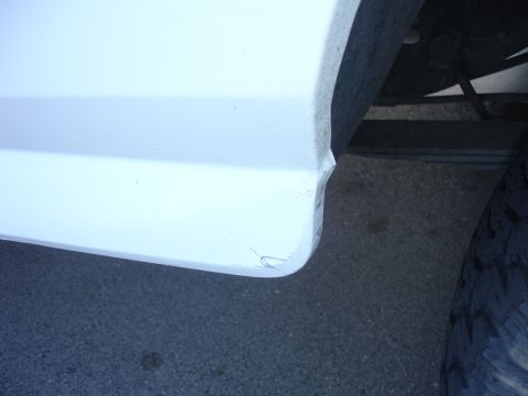1996 Ford Bronco - drivers side rear quarter infront of the tire bent in and bent back