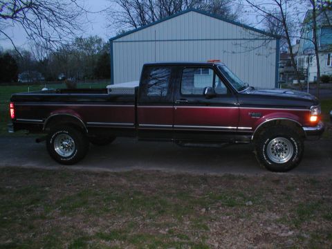 1979 Ford Bronco - This pickup truck, likely a 1995 model, is shown from the side with a two-tone paint scheme and a toolbox mounted in the bed.