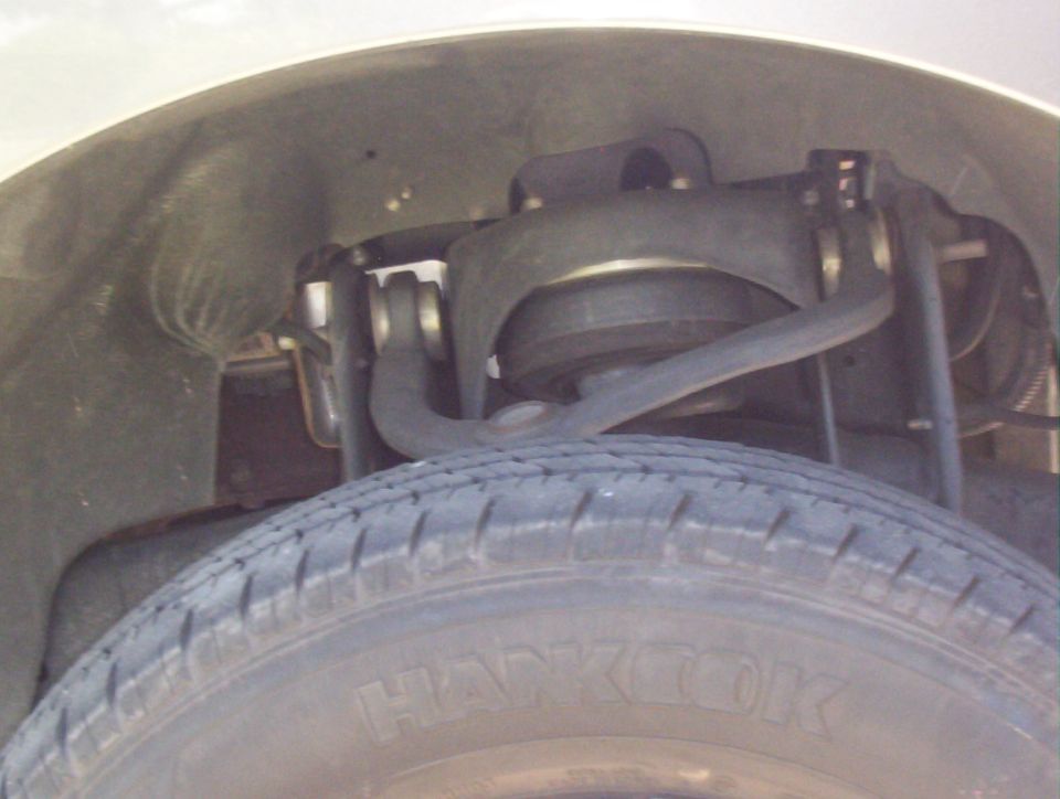 Front wheel well close-up showing upper control arm and suspension above a Hankook tire
