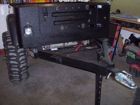 2003 Jeep TJ - Trailer hitch assembly with a large off-road tire attached, likely modified for off-road use.