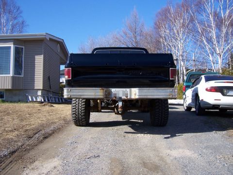 1996 Ford Bronco - Rear view of a black pickup truck with aftermarket wheels and tires.