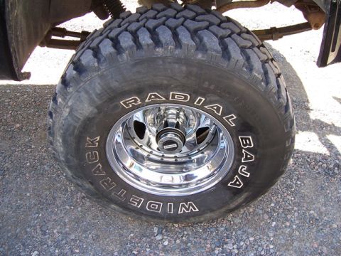 1996 Ford Bronco - Close-up of a vehicle's tire and chrome wheel with visible text.