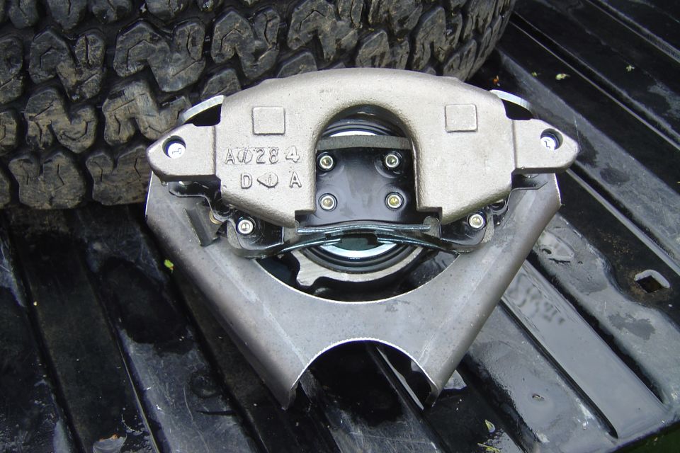 GM caliper bolted to bracket w/pads installed