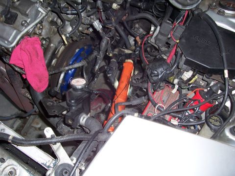 1996 Ford Probe - Close-up view of a cluttered engine bay, showing a fuse box, wiring, and an ignition coil.