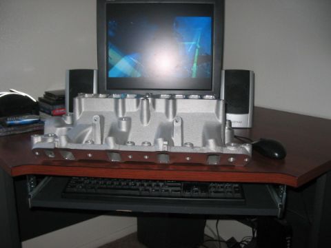 1991 Ford Bronco - An aluminum intake manifold is placed on a desk, obscuring a computer keyboard.
