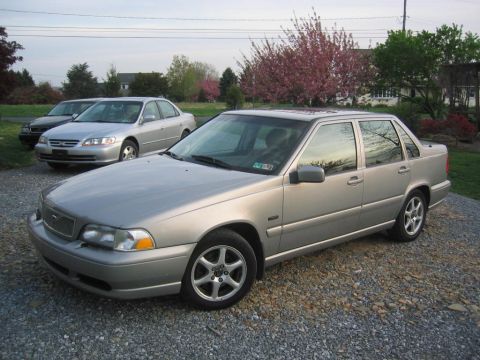 1993 Ford Probe - This silver Volvo sedan is parked on a gravel lot with other vehicles and trees in the background.