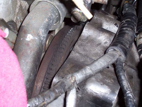 1996 Ford Probe - This is a close-up view of a vehicle's engine flywheel and transmission housing, showing some associated wiring and plumbing.