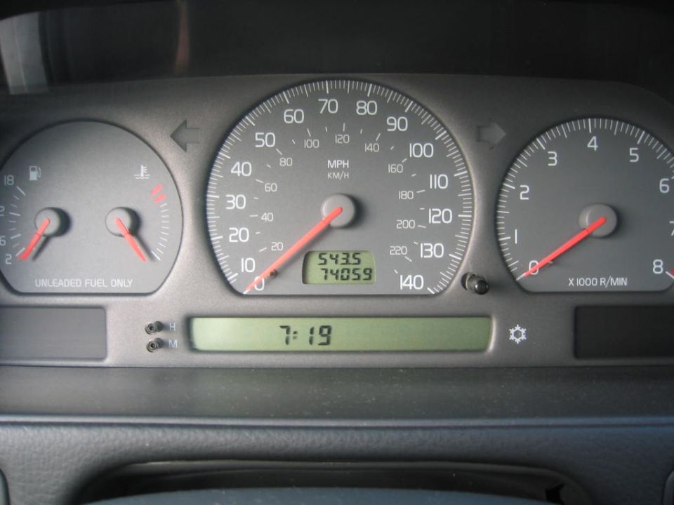 Car dashboard with speedometer, fuel gauge, temperature gauge, and digital clock showing 7:19. Odometer reads 5435.5 and trip odometer reads 74059