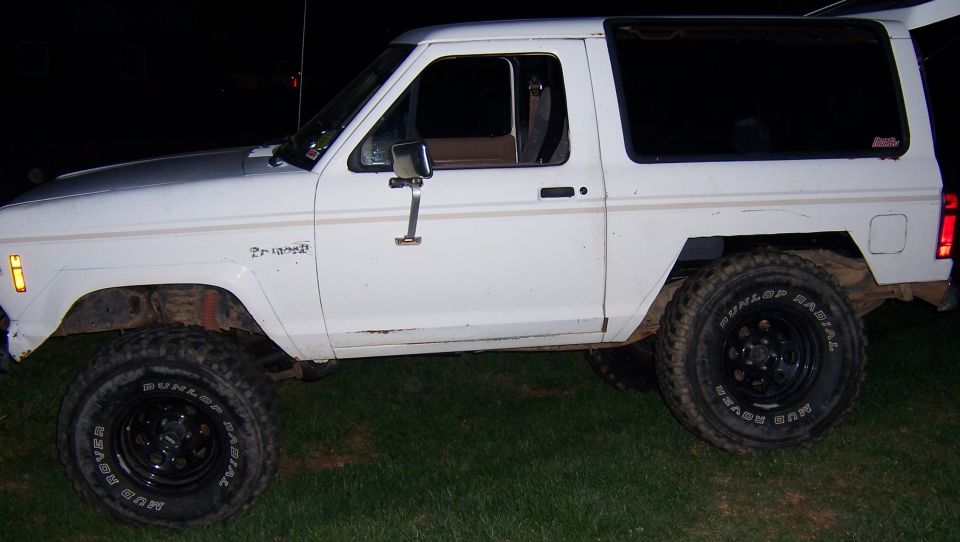 White 1984 Ford Bronco II SUV, side view, lifted with off-road tires, some rust on lower body panels