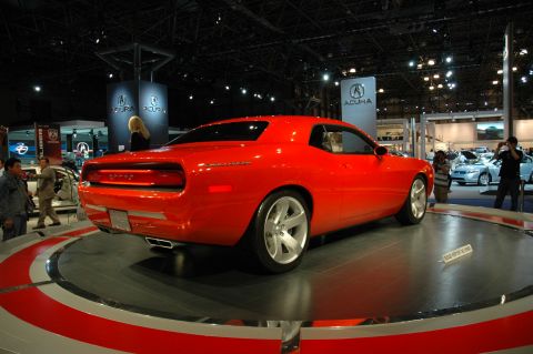 2005 Ford Mustang - A red Dodge Challenger concept car is displayed on a rotating platform at an auto show.
