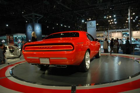 2005 Ford Mustang - A red Dodge Challenger concept car is displayed on a rotating platform at an auto show.