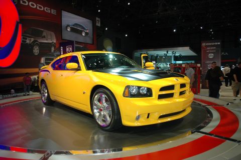 2005 Ford Mustang - A yellow Dodge Charger is displayed at an auto show with Dodge branding visible.