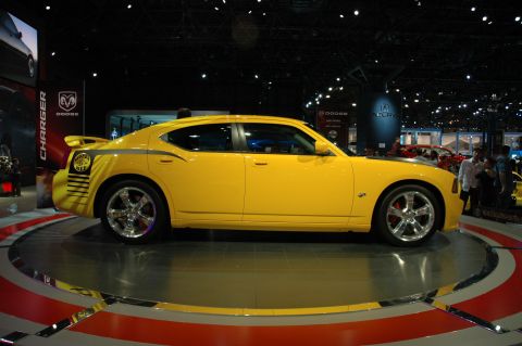 2005 Ford Mustang - A yellow Dodge Charger is displayed on a rotating platform at an auto show.