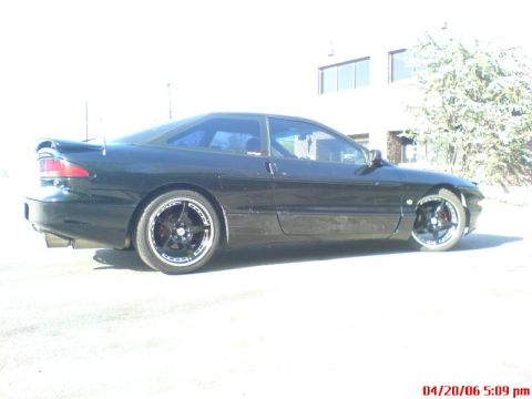 1997 Ford Probe - Side profile of a black coupe with custom wheels and a spoiler.