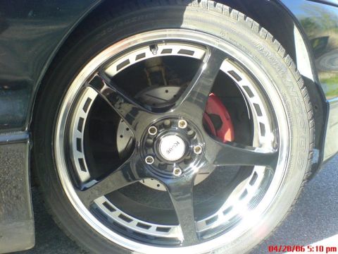 1997 Ford Probe - Aftermarket wheel and tire assembly with red brake caliper visible behind the spokes.
