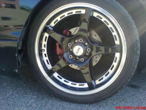 1997 Ford Probe - A close-up view of a custom wheel and tire assembly, a prominent aftermarket rim and red brake caliper.