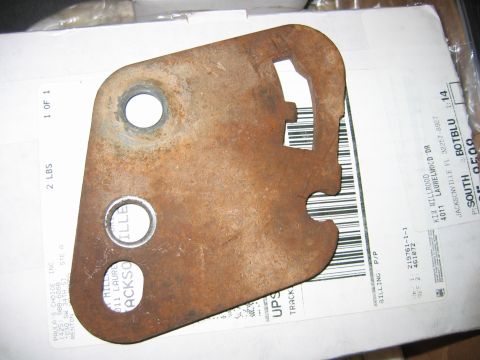 1992 Ford Bronco - A rusty metal bracket, likely a transfer case component, is shown against a shipping label.