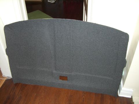 1988 Ford Bronco - A dark gray carpeted trim panel, likely from a vehicle's rear cargo area, is shown with a rectangular cutout.
