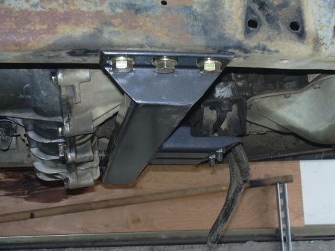 1991 Ford Bronco - Underside view of a vehicle's transmission and frame with an aftermarket crossmember bracket installed.