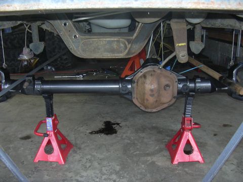 1991 Ford Bronco - Rear axle assembly supported by jack stands in a garage setting.