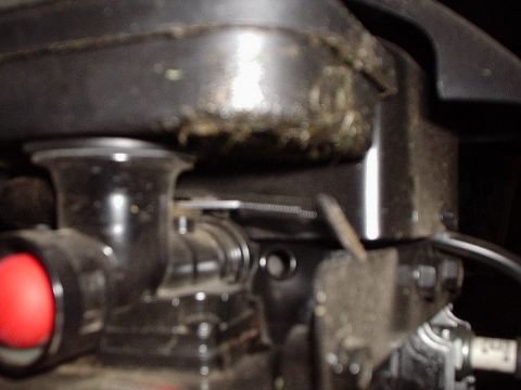 1990 Ford Bronco - Close-up of an engine part with visible grass and dirt accumulation.