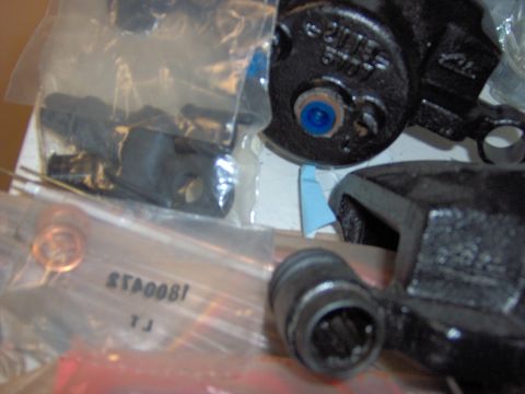 1993 Ford Probe - Close-up of various brake caliper components and hardware, some in packaging.