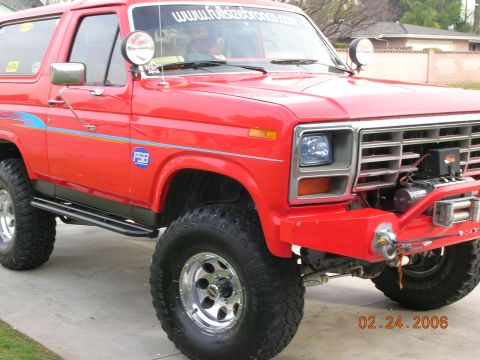 1985 Ford Bronco - This red 1985 Ford Bronco features a winch and off-road tires, suggesting it's ready for adventure.