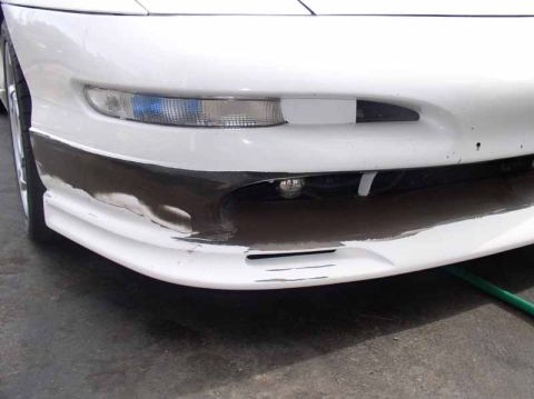 1996 Ford Probe - Front view of a 1996 Ford Probe GT's bumper, showing damage to the black trim section.