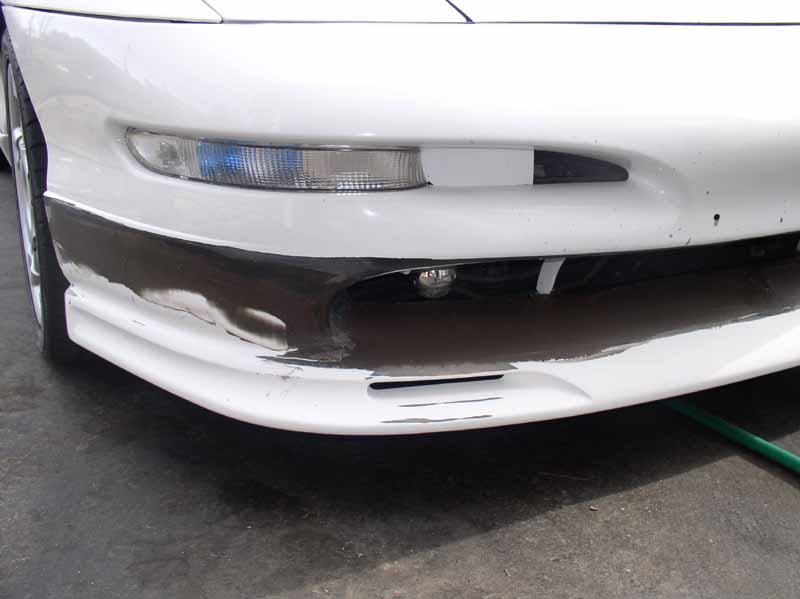 Front bumper of a white 1996 Ford Probe GT with black trim and some scuff marks