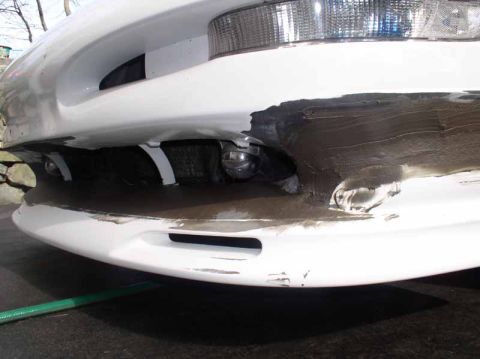 1996 Ford Probe - Front bumper shows significant damage and what appears to be a rough repair job.