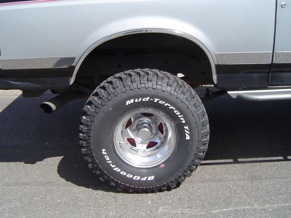 BFGoodrich Mud-Terrain T/A tire on polished slotted wheel under a lifted silver Ford
