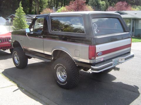 1989 Ford Bronco - This lifted Ford Bronco features a two-tone paint scheme with red and silver accents on the rear quarter panel.