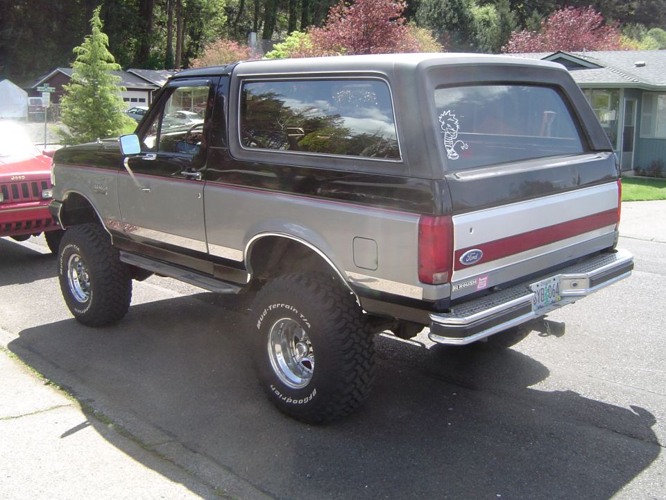 Lifted two-tone gray Ford Bronco on BFGoodrich mud tires, rear three-quarter view