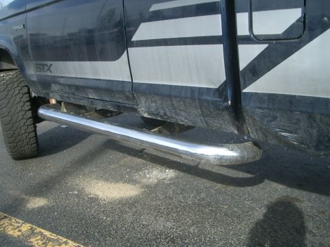 1992 Ford Ranger - The side of a dark-colored Ford Ranger STX pickup truck, showing the door and running boards.