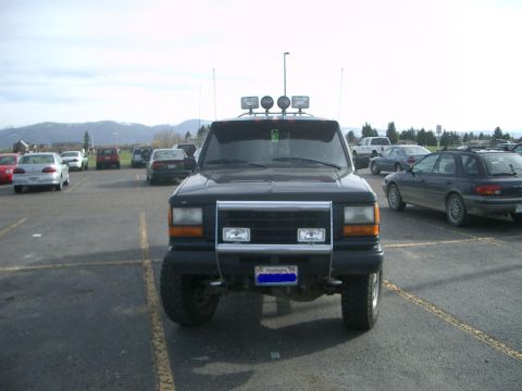 1992 Ford Ranger - A black 1992 Ford Ranger is parked in a lot, a prominent chrome grille guard and auxiliary lights on the roof.