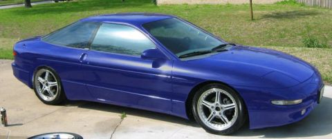 1997 Ford Probe - A blue 1997 Ford Probe is shown from a three-quarter front view, parked on a concrete driveway.
