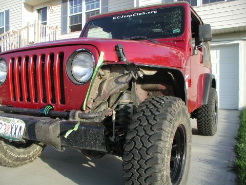 1998 Jeep TJ - Front view of a red Jeep Wrangler showing damage to the front fender area.