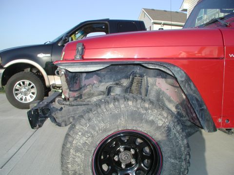 1998 Jeep TJ - A red Jeep Wrangler is parked next to a black Ford F-150 truck.