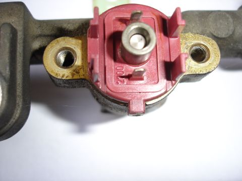 1993 Mazda MX-3 - Close-up of a fuel rail a red plastic connector with visible '2700' markings.