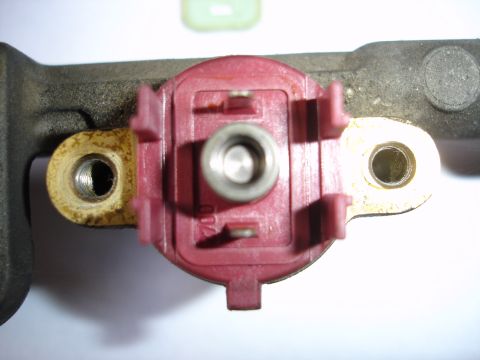 1993 Mazda MX-3 - A close-up view of a fuel injector rail component with visible markings.