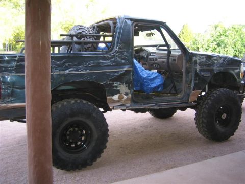 1994 Ford Bronco - This modified Ford Bronco has its doors removed and a roll cage installed, sitting on large off-road tires.