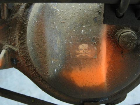 1987 Suzuki Samurai - A close-up of a differential housing shows a warning sticker and orange paint.