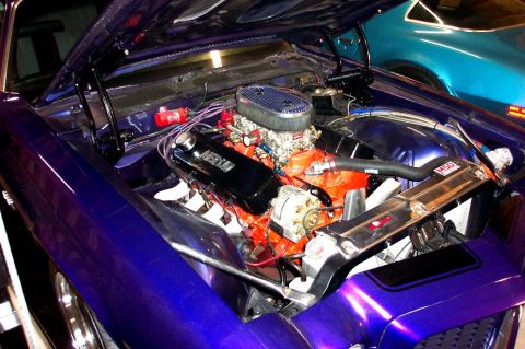 1970 Chevrolet Camaro - The engine bay of a purple 1970 Chevrolet Camaro is open, revealing its V8 engine and chrome accents.