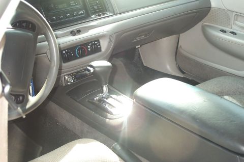1999 Ford Crown Victoria - Interior view of a gray Ford Crown Victoria showing the center console with automatic shifter, aftermarket radio head unit, climate control…